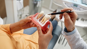 Dentist showing patient model of dental implant in Phoenix, AZ