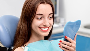 Woman examining her smile following teeth whitening