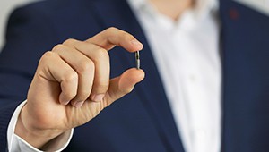 Man holding a single dental implant in Phoenix, AZ