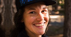 Person in baseball cap smiling outdoors