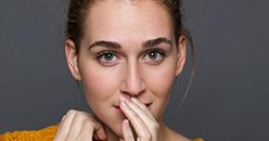 Young woman covering her mouth with her hand