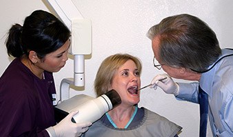 Dentist and assistant working with patient