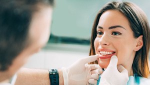 Dentist checking a woman’s smile after cosmetic dentistry in Phoenix, AZ 