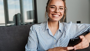 Woman in a striped shirt smiling on couch