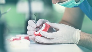 Close up of hand holding full denture 