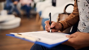 Closeup of patient filling out dental insurance information