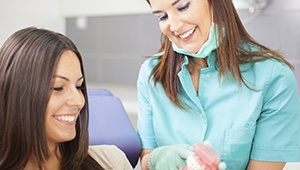 Patient and dental hygienist looking at smile model