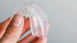 Closeup of patient holding clear mouthguard