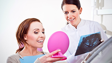 Woman looking at her smile after a makeover