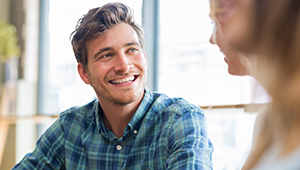 Man with veneers in Phoenix smiling at lunch with friends