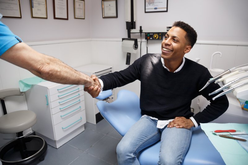 Patient shaking dentist’s hand during a checkup