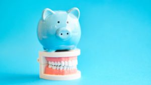 piggy bank atop model teeth representing cost of sedation dentistry in Phoenix