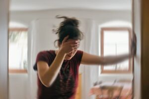 Woman leaning against wall, experiencing vertigo